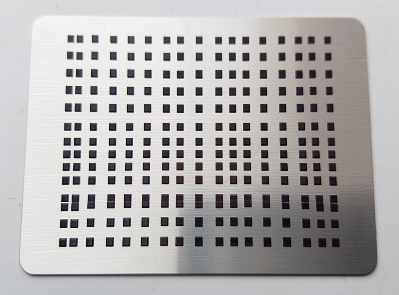 Power and speed test grid of small dark marked squares on a brushed stainless steel coupon