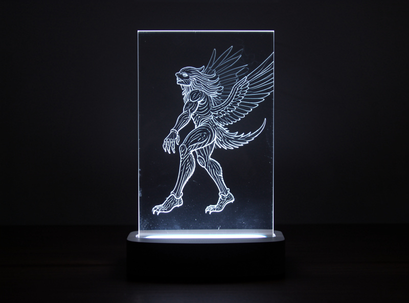 Clear acrylic panel standing in an LED base in a dark room with an engraved design glowing brightly while the rest of the sheet stays invisible