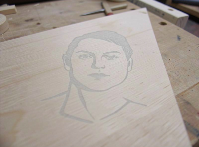 A faint, washed-out, low-contrast laser-engraved portrait on pale wood that came out too light