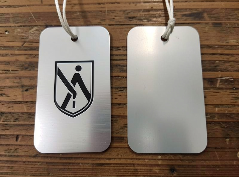 Comparison of a bright fiber-marked anodized tag next to a softer diode-bleached one