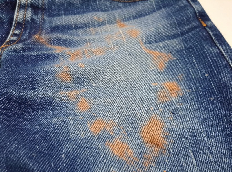 Diode laser engraving a faded distressed design into a denim panel taped flat on the bed
