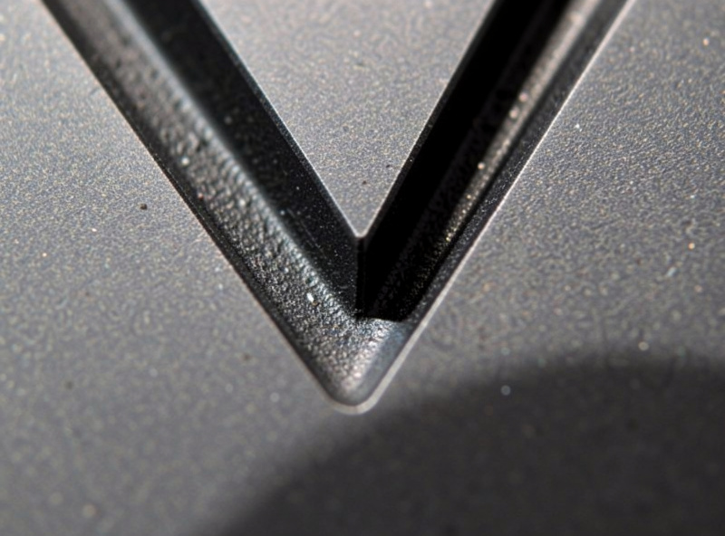 Deep engraved V-shaped recess cut into steel showing real material removal